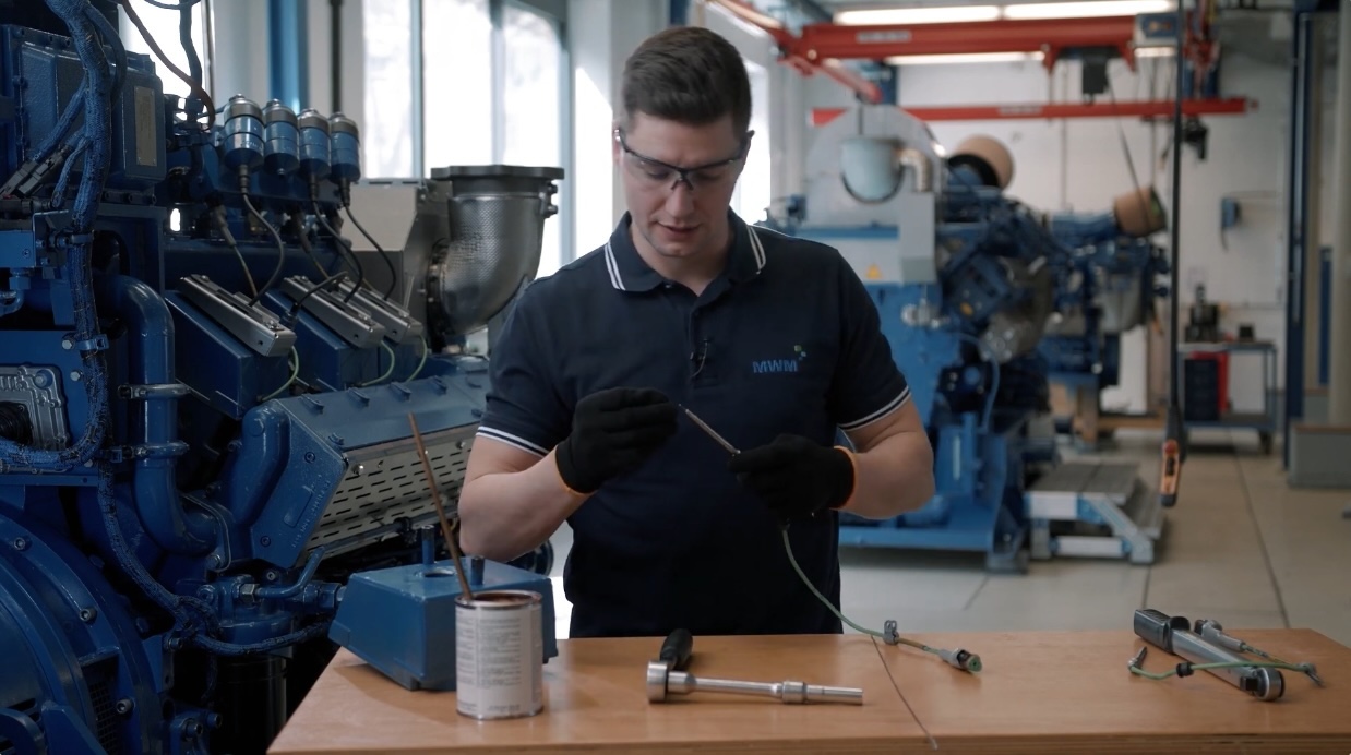 Alexander Klotz, Technical Trainer at the Learning Center Service in Mannheim, demonstrates the replacement of the combustion chamber temperature sensor on the MWM gas engine. 