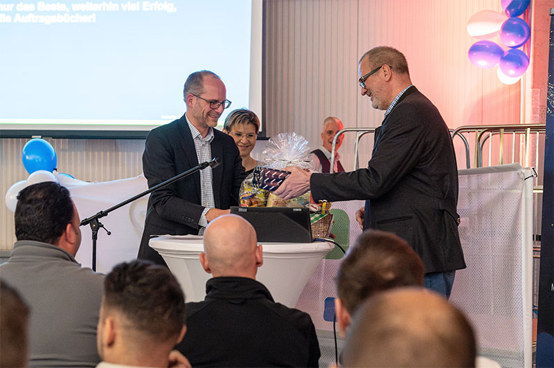 Torsten Werda (a la derecha en la foto) recibió la despedida de toda la plantilla del MWM Service-Center Nord con los mejores deseos para su merecida jubilación a través de Karl Vollrath y Anna Wessel. (Foto: © Kolja Raschke)